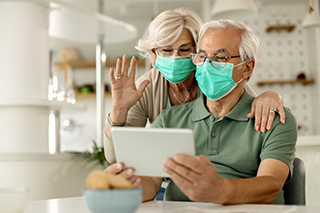 Mann und Frau mit Maske und Tablet